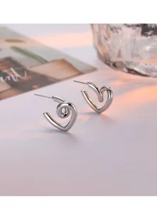 Vue détaillée de boucles d'oreilles tendance en métal avec design de cœur spiralé.