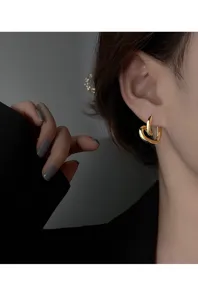 Vue de détail des boucles d'oreilles cœur abstrait en or, élégants bijoux de mode minimalistes.