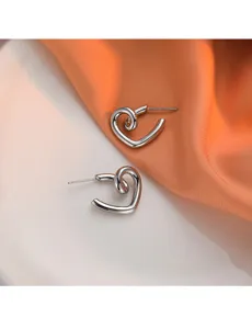 Boucles d'oreilles clous cœur tordu en métal argenté, bijoux géométriques épurés.