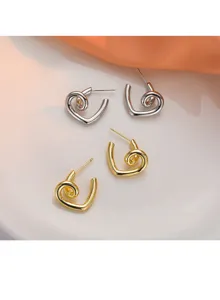 Vue détaillée de boucles d'oreilles cœur exquises avec finition métallique brillante.