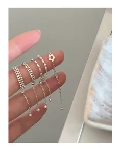 Close-up of minimalist stacked pull-chain silver rings with delicate bead details.