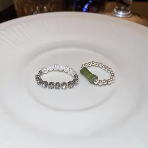 Anello elastico artigianale di perle e strass con anello in giada verde in dettaglio