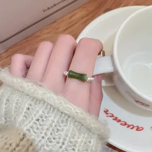 Dettaglio anello di bambù in giada verde delicato, gioiello elastico vintage elegante.