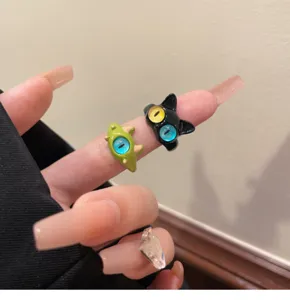 Closeup detail of cute cartoon cat and little monster open rings with colorful eye design.