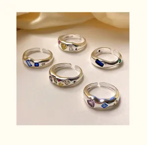 Schicke silberne offene Ringe mit bunten Zirkoniasteinen besetzt, elegantes Detail.