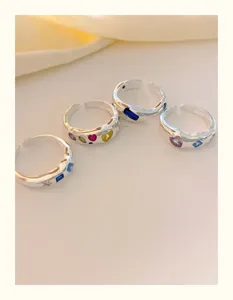 Detailansicht farbiger Zirkonia Ringe mit Herz, elegante silberne Modeschmuckstücke.
