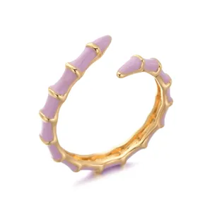 Detailed close-up view of gold and purple enamel bamboo ring, chic adjustable open design.