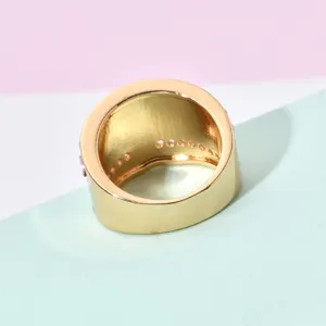Detailed view of wide gold-colored retro ring with inner embellishments, stylish jewelry piece.