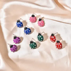 Detailed view of colorful ladybug rhinestone enamel stud earrings, cute insect jewelry.