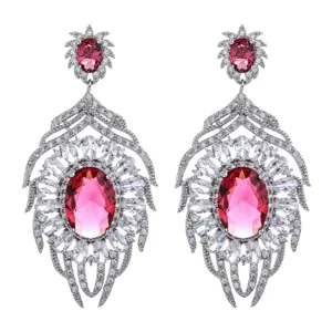 Primo piano dettagliato di lussuosi orecchini pendenti in zircone ovale rosa e cristalli.