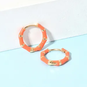 Orangerad, vergoldeter Bambus-Creolen Detailaufnahme, schickes Retro-Design für Damen.