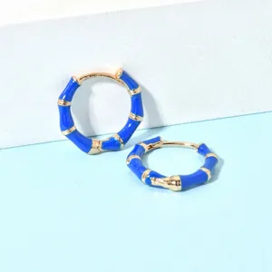 Detailaufnahme eleganter blauer Bambus-Creolen, modernes schickes Design fuer den Alltag.