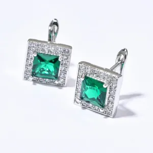 Close-up detail of square green cubic zirconia halo earrings with delicate pave stones.
