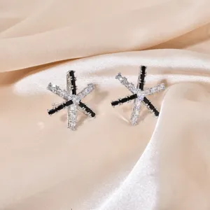 Detailed shot of geometric star earrings featuring black and white baguette cubic zirconia.