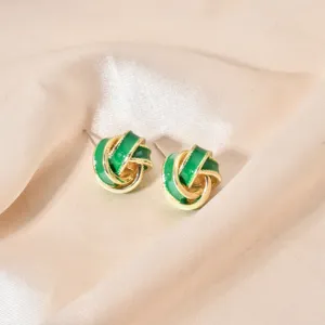 Detailed close-up of green enamel knot earrings, showcasing glossy gold finish with clear view.