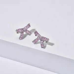 Close-up detail of sparkling pink zircon bow earrings featuring exquisite baguette cut stones.