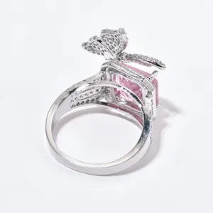 Vista dettagliata di un anello color argento con uno zircone rosa e un piccolo papillon.