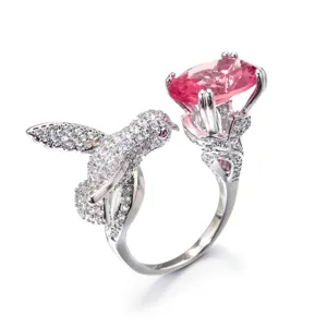 Exaktes Detail des Kolibri-Rings mit rosa Edelstein und funkelnden Zirkonia-Steinen.