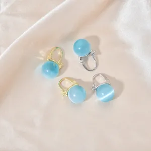 Nahaufnahme Detailansicht eleganter blauer Katzenauge-Ohrringe in Gold- und Silber-Ausführung.