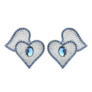 Exquisite double heart cubic zirconia stud earrings with sparkling blue main stone detail.