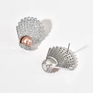 Detailed view of exquisite shell shaped cubic zirconia stud earrings with a lovely pink pearl.
