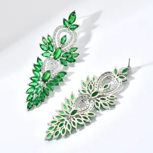 Vista dettagliata di lunghi orecchini pendenti in zircone verde marquise per feste di donna.