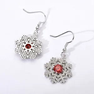 Close-up detail of silver snowflake dangle earrings featuring brilliant red center zircon stones.