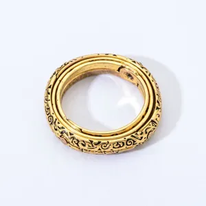 Detailed close-up of vintage gold armillary sphere ring featuring intricate engraved bands.