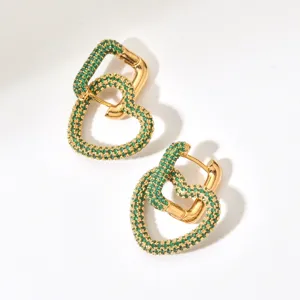 Close-up of gold-plated green zircon pavé interlocking heart earrings, elegant and sparkling.