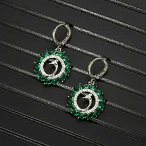 Green zircon swan earrings close-up view, elegant silver fashion jewelry detail shot.