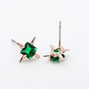 Primo piano dettagliato di orecchini a lobo con zircone verde quadrato e punte in oro rosa.