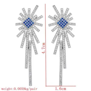 Detailed shot of sparkling cubic zirconia tassel earrings with blue square center stones.