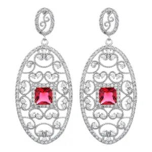 Eleganti orecchini lunghi ovali in zircone con pietra rossa centrale. Dettagli.