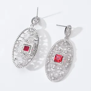 Eleganti orecchini pendenti ovali con cristallo rosso e zirconi brillanti e luminosi.