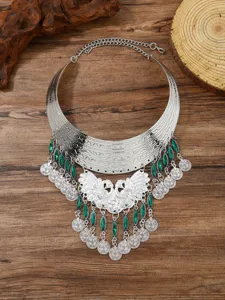 Detailed view of vintage bohemian peacock tassel statement necklace with green stones.