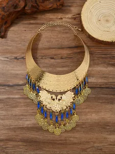 Detailed close-up of the vintage gold peacock tassel statement collar necklace with blue stones.