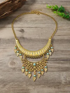 Detailaufnahme der goldenen Statement-Halskette im Boho-Stil mit Türkisen und Strasssteinen.