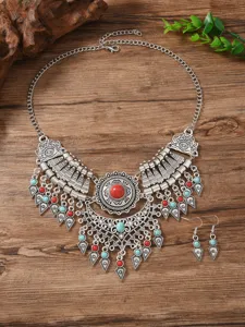 Detailed shot of vintage ethnic style layered necklace and matching earrings with red stones.