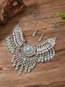 Close-up details of vintage bohemian turquoise necklace and earrings set with silver filigree.