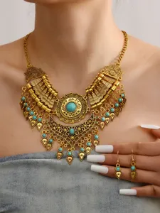Close-up detail of bohemian vintage gold statement necklace and earrings with turquoise stones.