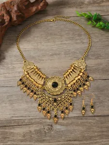 Vintage gold ethnic necklace and earrings set detail view with black gemstone accents.