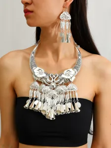 Vue de détail en gros plan du collier torque éléphant argenté ethnique et des boucles d'oreilles.