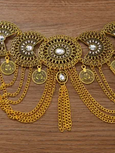 Detailopname van de gouden buikdans tailleketting met fonkelende strass-steentjes en munten.