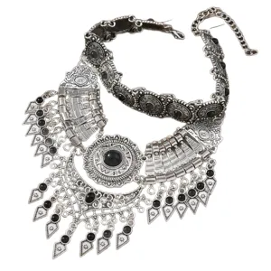 Vintage ethnischer Stil Statement Halskette mit filigraner Metall Schnitzerei und Steinen.