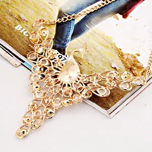 Gold peacock statement necklace detail, intricate filigree and sparkling crystal accents.
