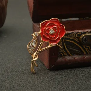 Detailed close-up of a stunning red enamel carnation brooch adorned with sparkling rhinestones.