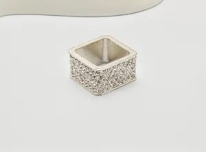 Nahaufnahme des quadratischen Strass-Schalrings, glitzernde Kristalldetails und Metallbasis.