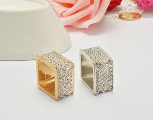 Nahaufnahme quadratischer Strass Serviettenringen und Schalringe mit funkelnden Details.