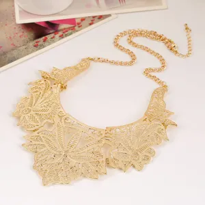 Close-up of gold-plated cutout floral lace bib necklace, ornate metal statement collar.