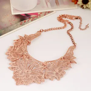 Rose gold tone metal filigree lace bib necklace with intricate floral cutout design and chain.